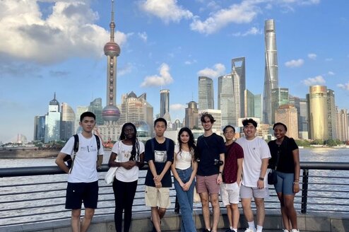 Students posing with Shanghai skyline behind them 